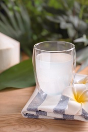 Photo of Glass with fresh coconut water on wooden table