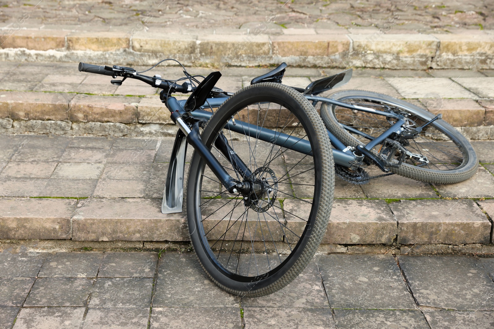 Photo of Fallen beautiful modern bicycle on steps outdoors