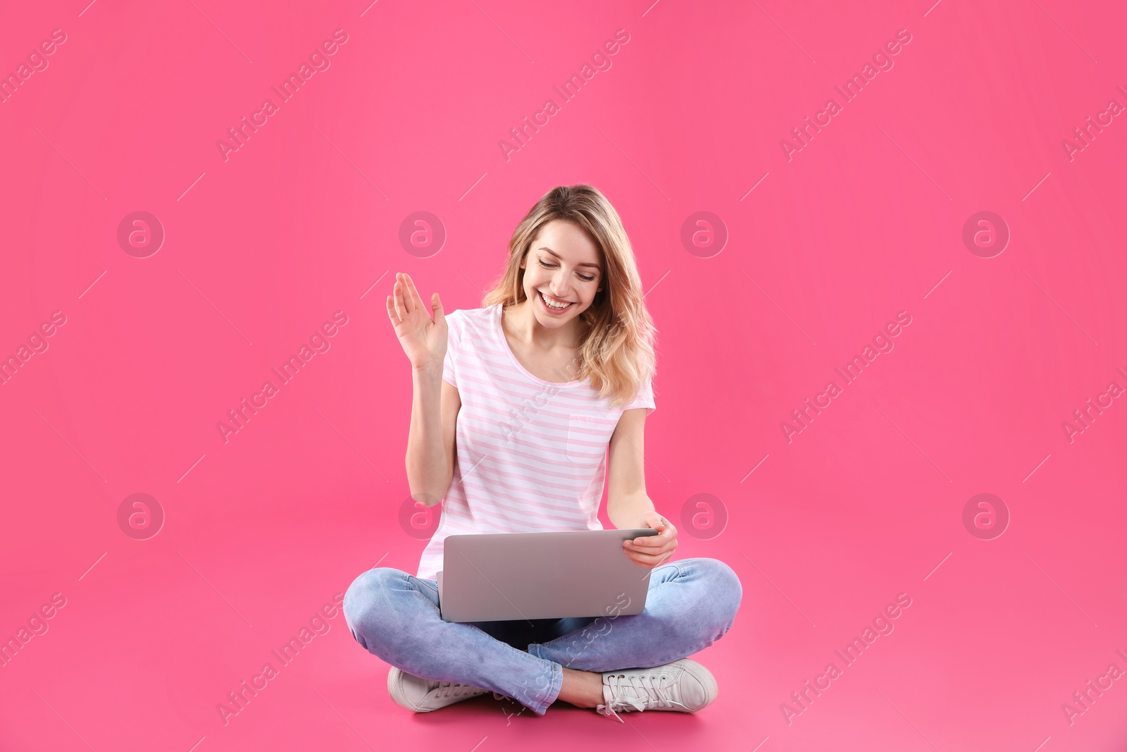 Photo of Woman using laptop for video chat on color background