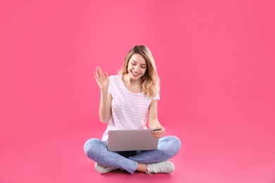 Photo of Woman using laptop for video chat on color background