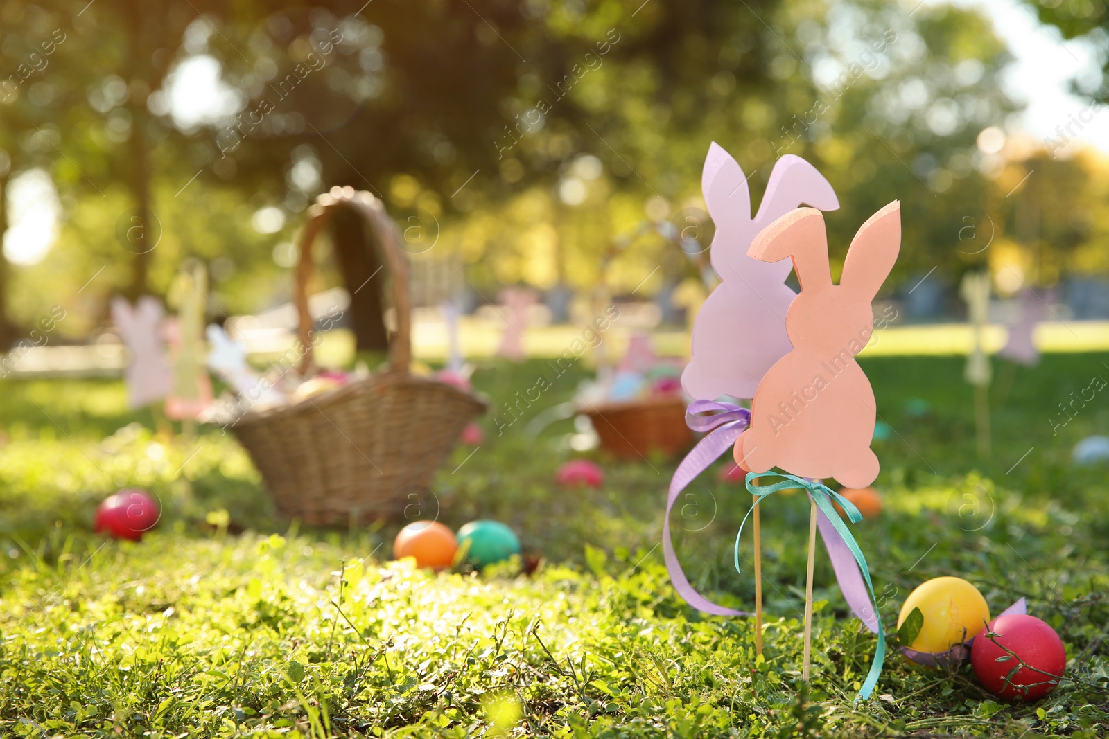 Photo of Easter decor and eggs on grass in park. Space for text