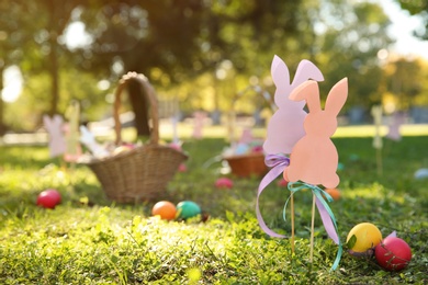Photo of Easter decor and eggs on grass in park. Space for text