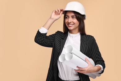 Architect in hard hat with drafts on beige background, space for text