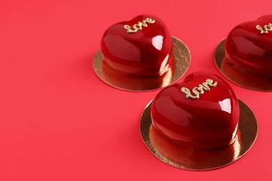 St. Valentine's Day. Delicious heart shaped cakes on red background, closeup. Space for text