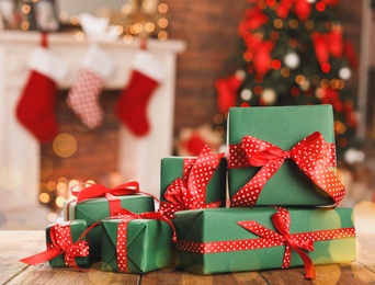 Christmas gift boxes on wooden table in room, bokeh effect