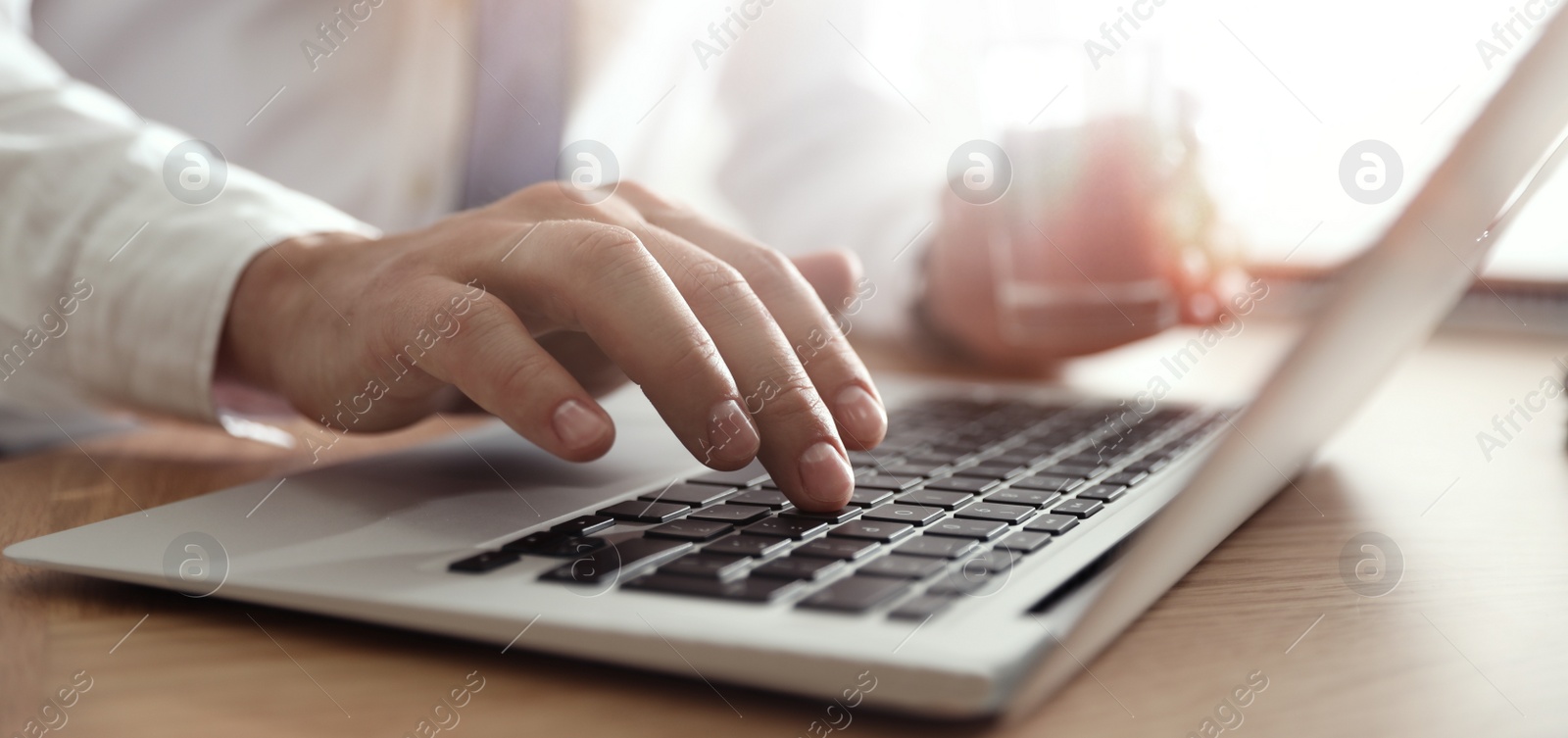 Image of Man working on computer at table in office, closeup. Banner design