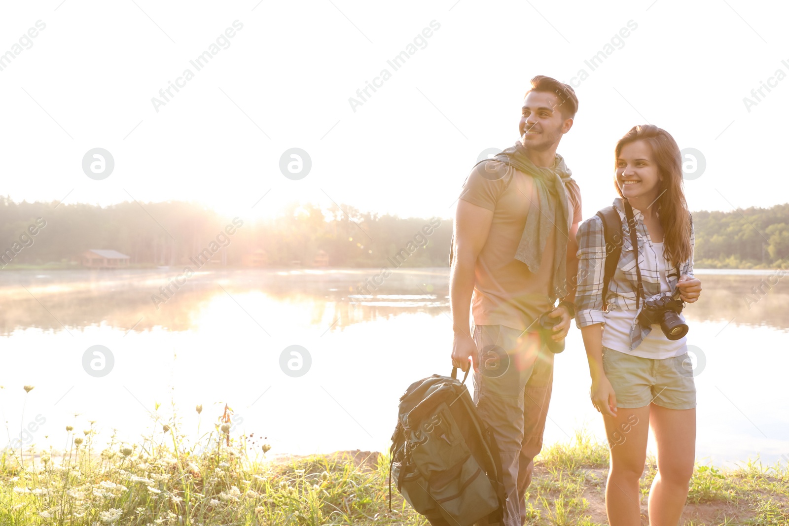 Photo of Young couple on shore of beautiful lake. Camping season