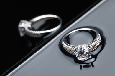 Photo of Luxury jewelry. Elegant ring on grey mirror surface, closeup with space for text