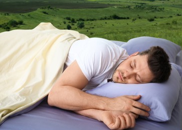 Man sleeping in bed and beautiful view of green lawn on background. Sleep well - stay healthy