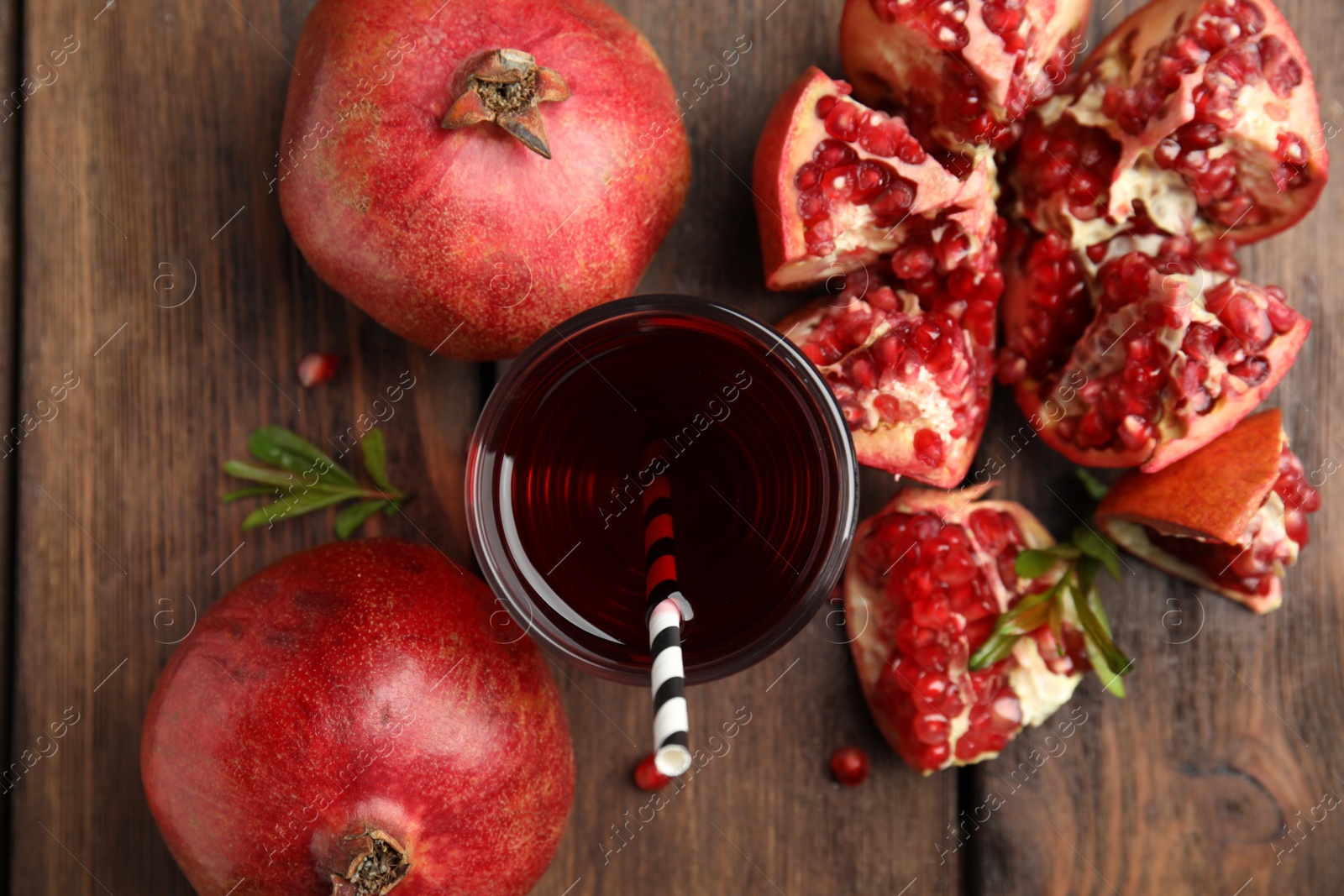 Photo of Pomegranate juice and fresh fruits on wooden table, flat lay