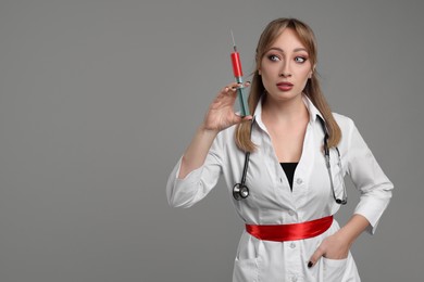 Woman in scary nurse costume with syringe on light grey background, space for text. Halloween celebration