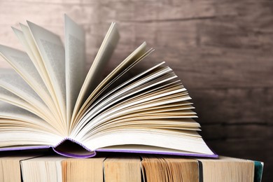 Photo of Different books against wooden background, closeup. Space for text