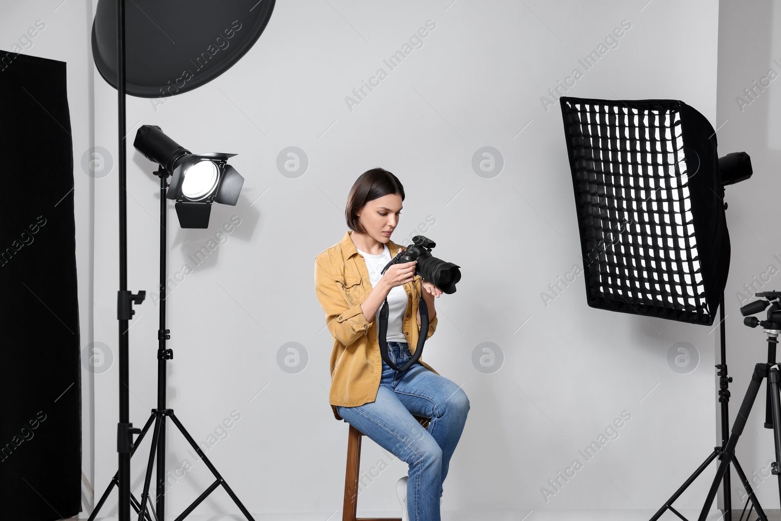 Photo of Professional photographer with camera in modern photo studio