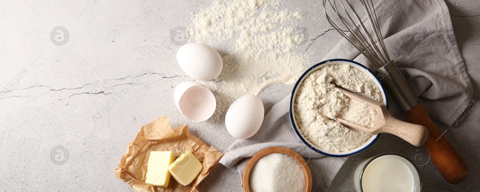 Photo of Different ingredients for dough and whisk on light textured table, flat lay. Space for text