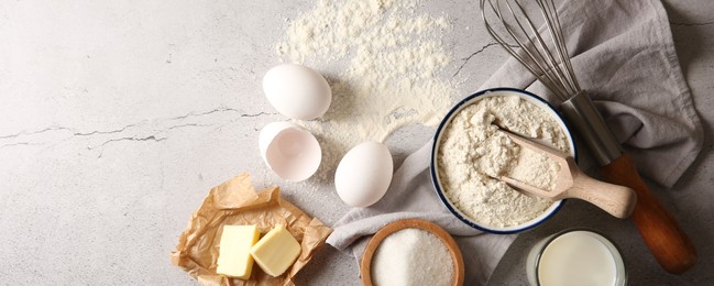 Photo of Different ingredients for dough and whisk on light textured table, flat lay. Space for text