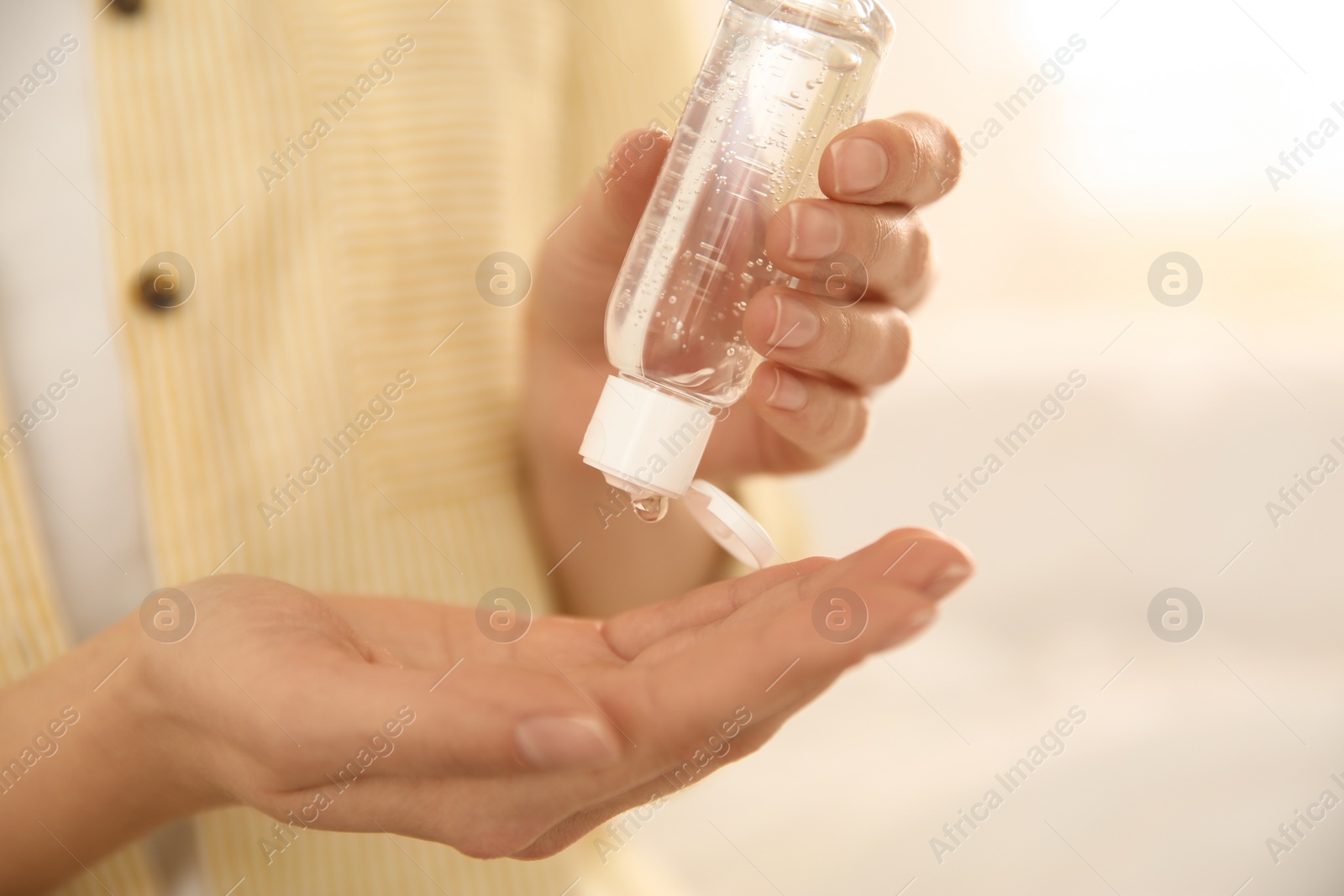 Photo of Woman applying antiseptic gel on blurred background, closeup