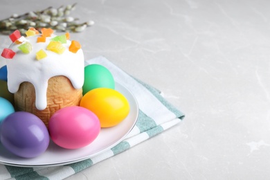Photo of Beautiful Easter cake and painted eggs on light grey marble table. Space for text