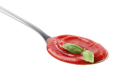 Spoon with tasty ketchup and basil isolated on white