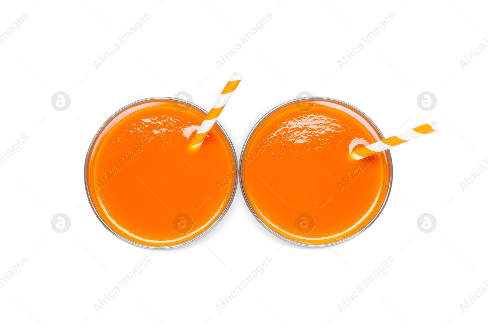 Photo of Two glasses of carrot juice with straws on white background, top view