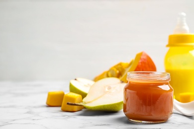 Photo of Healthy baby food and fresh ingredients on white marble table. Space for text