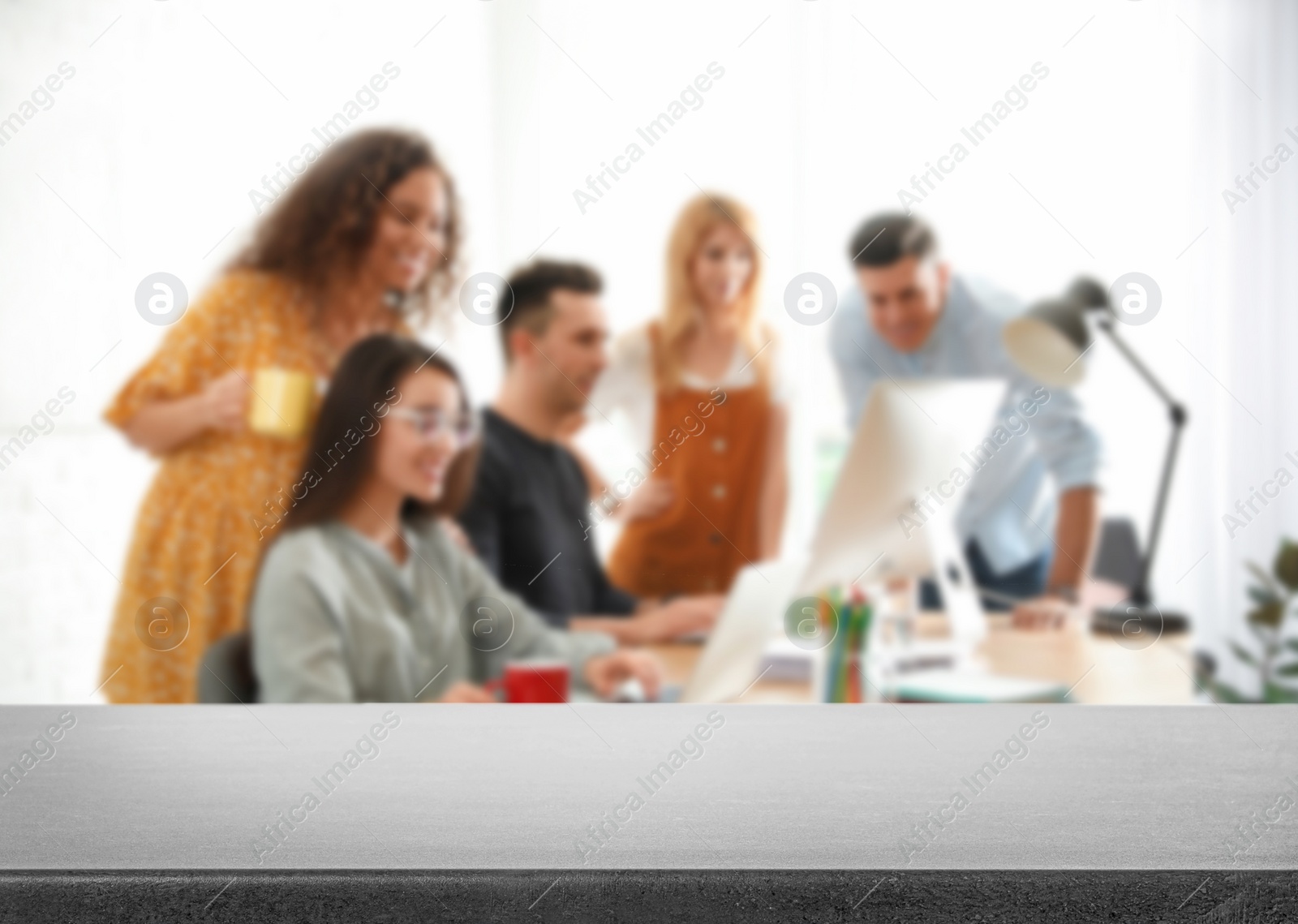 Image of Empty stone surface and blurred view of professional interior designers working in office, closeup. Space for text 