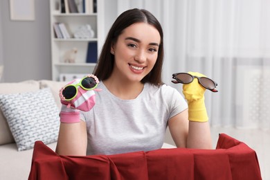 Photo of Happy woman performing puppet show at home