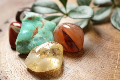 Citrine quartz and beautiful gemstones on wooden stand, closeup