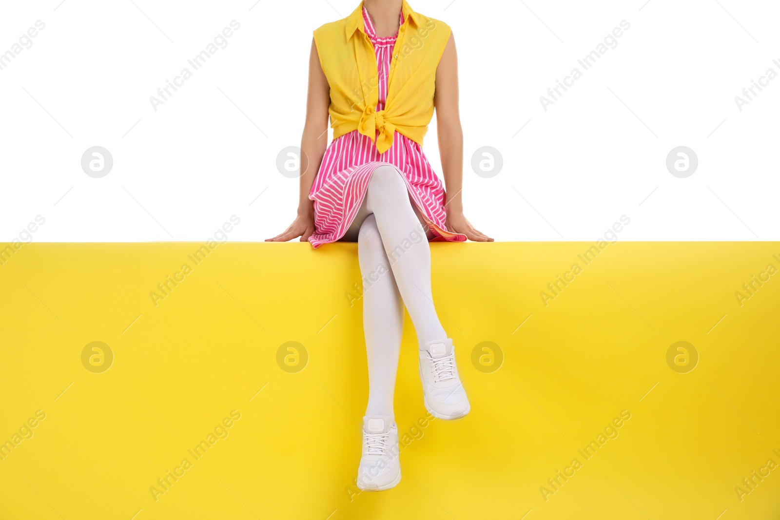 Photo of Woman wearing white tights sitting on color background, closeup