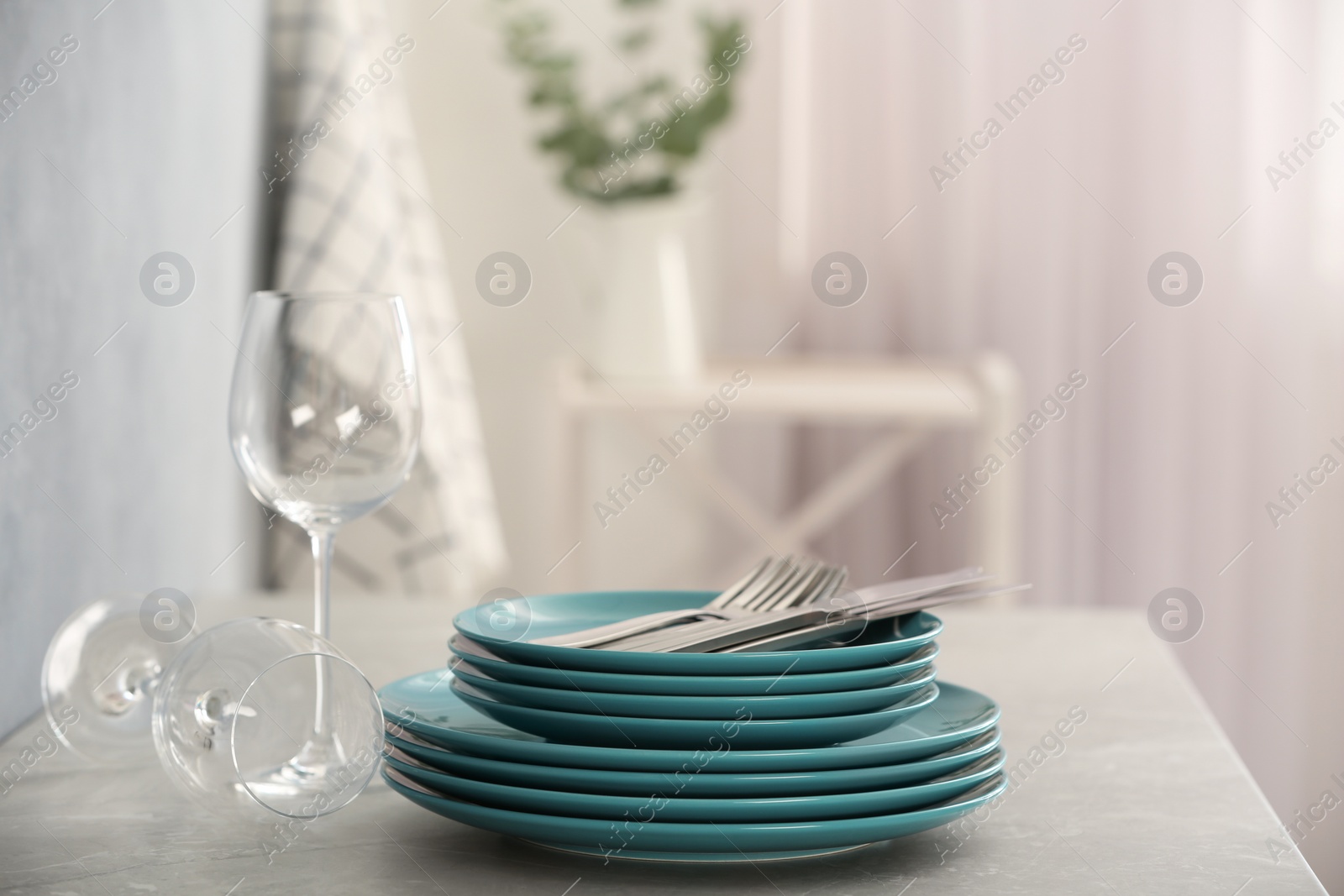 Photo of Setclean dishware, cutlery and wineglasses on grey table indoors. Space for text