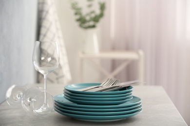 Photo of Set of clean dishware, cutlery and wineglasses on grey table indoors. Space for text