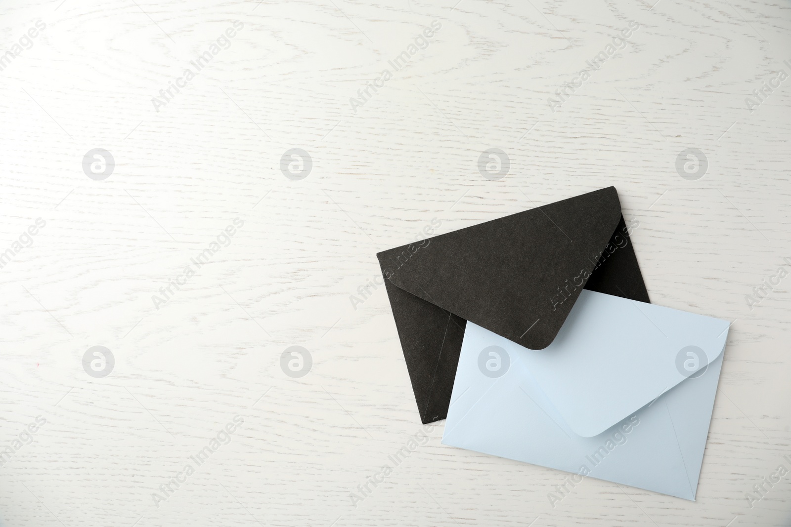 Photo of Paper envelopes on white wooden background, flat lay. Space for text