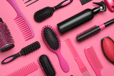 Flat lay composition with modern hair combs and brushes on pink background