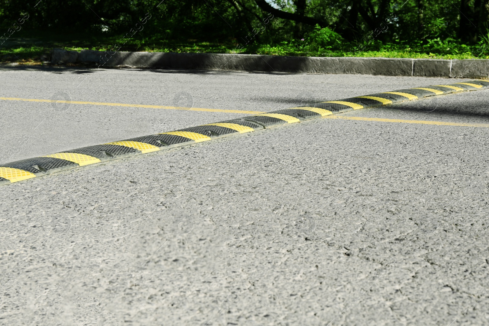 Photo of Speed bump on empty asphalt road. Traffic calming