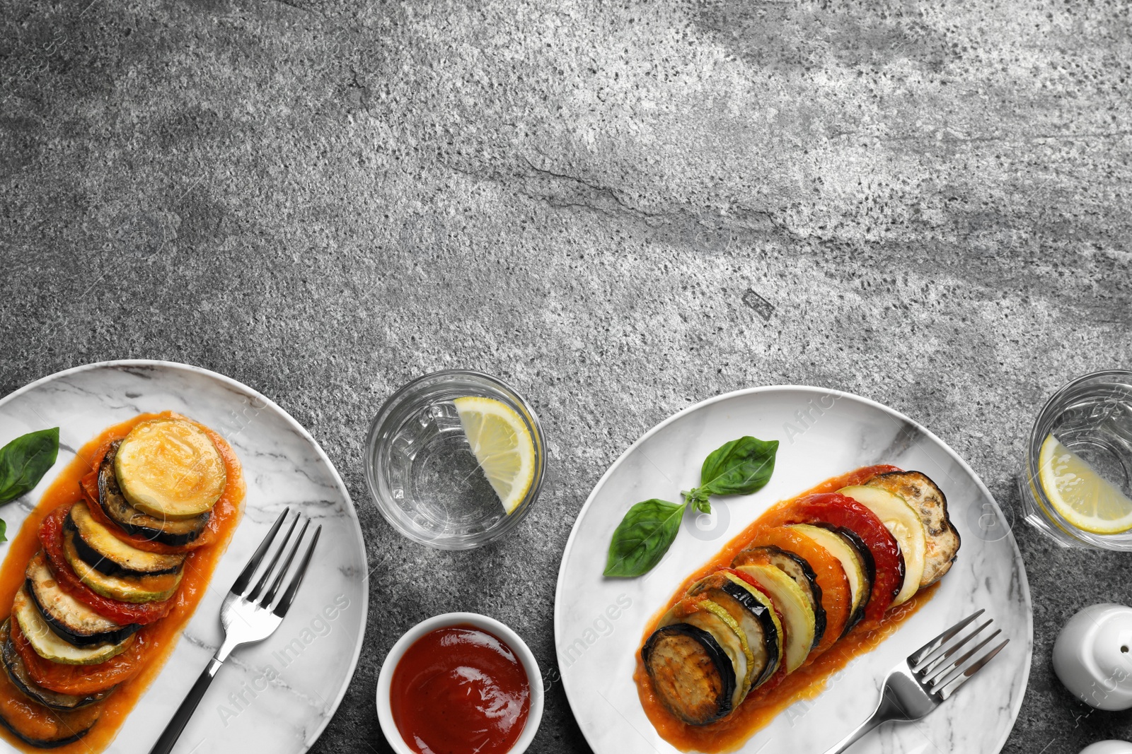 Photo of Delicious ratatouille served on grey table, flat lay. Space for text