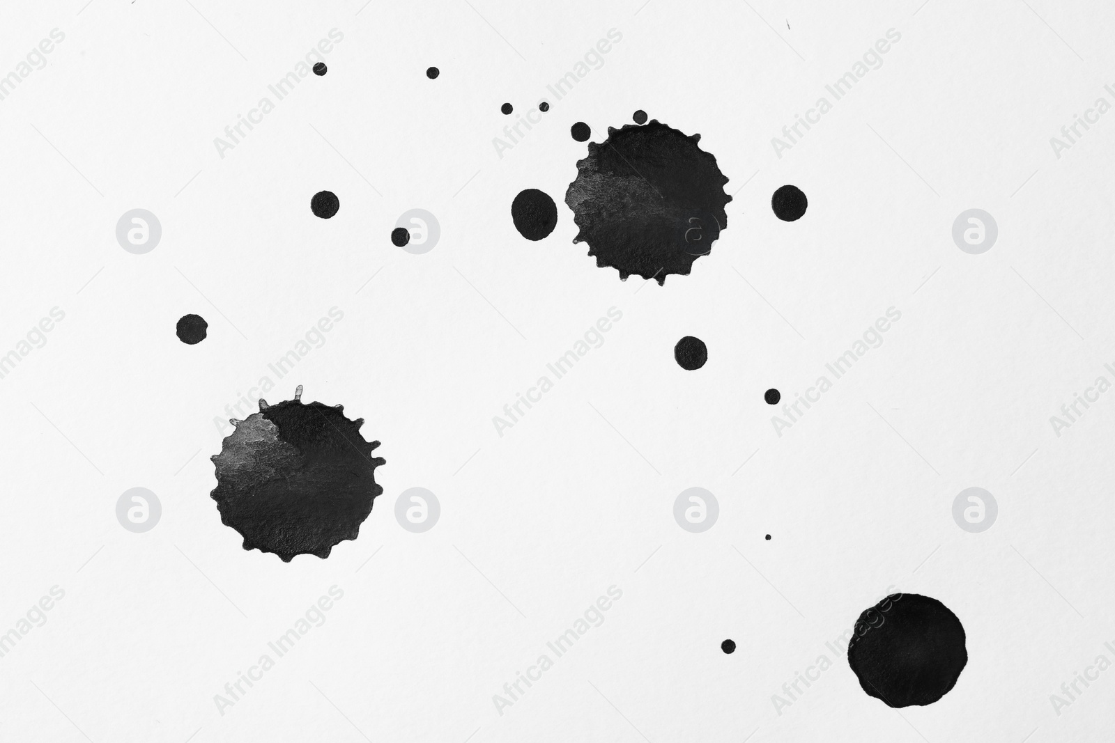 Photo of Blots of black ink on white background, flat lay