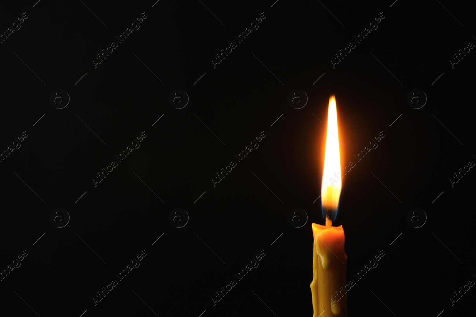 Photo of Burning candle on dark background, space for text. Symbol of sorrow