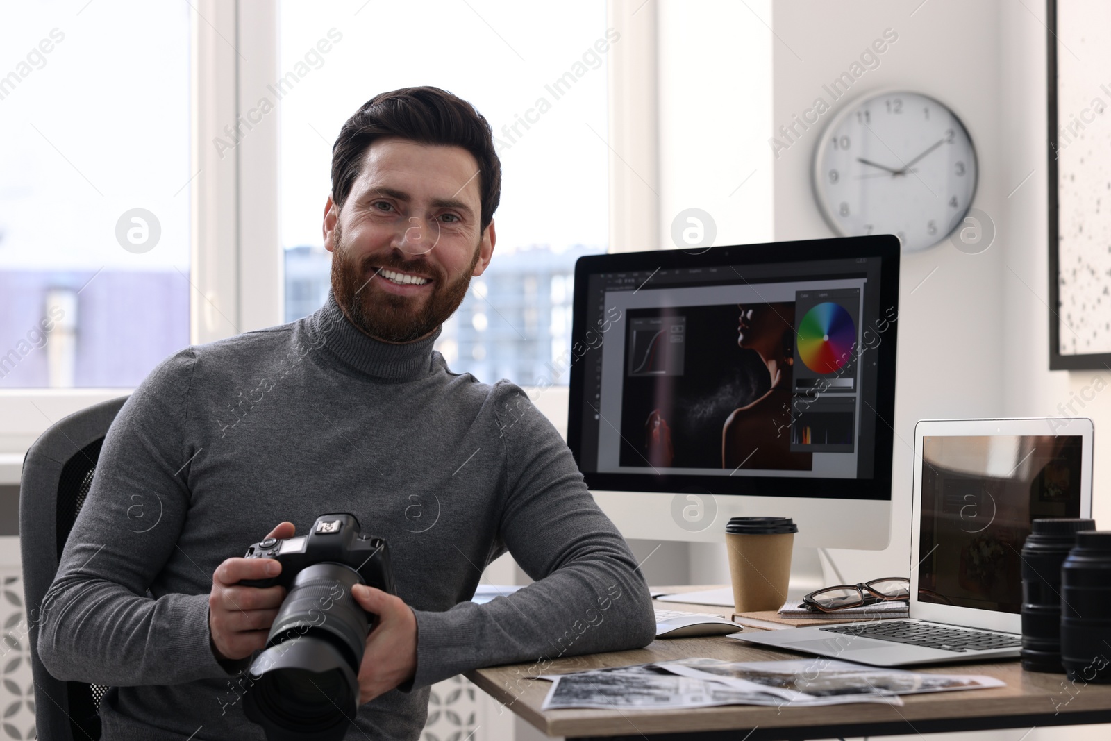 Photo of Professional photographer with digital camera at table in office