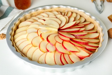 Photo of Raw traditional English apple pie in baking dish on white table, closeup