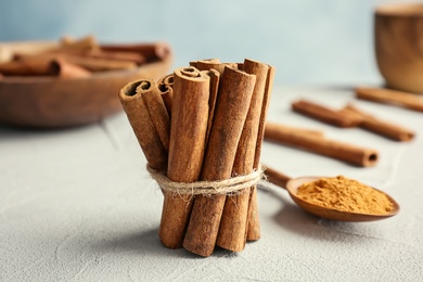 Photo of Tied cinnamon sticks on table, closeup