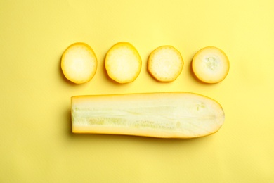 Photo of Fresh ripe cut zucchini on yellow background, flat lay