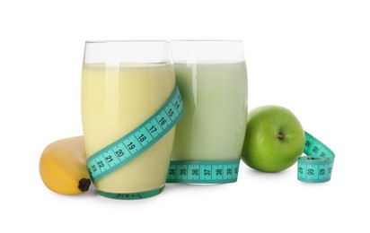 Photo of Tasty shakes, banana, apple and measuring tape isolated on white. Weight loss