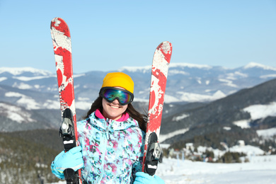 Photo of Young woman with ski equipment in mountains. Winter vacation