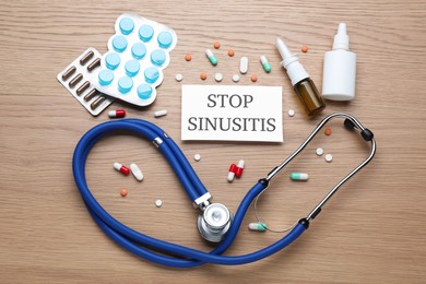 Photo of Flat lay composition of card with words Stop Sinusitis, stethoscope and remedies on wooden table