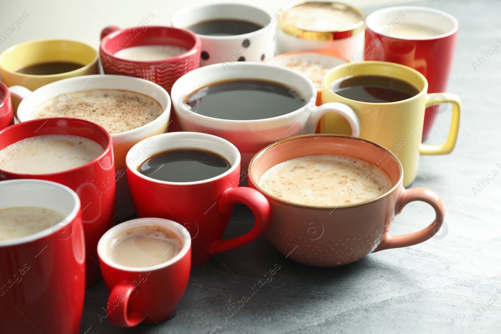 Photo of Many cups of different coffees on grey table