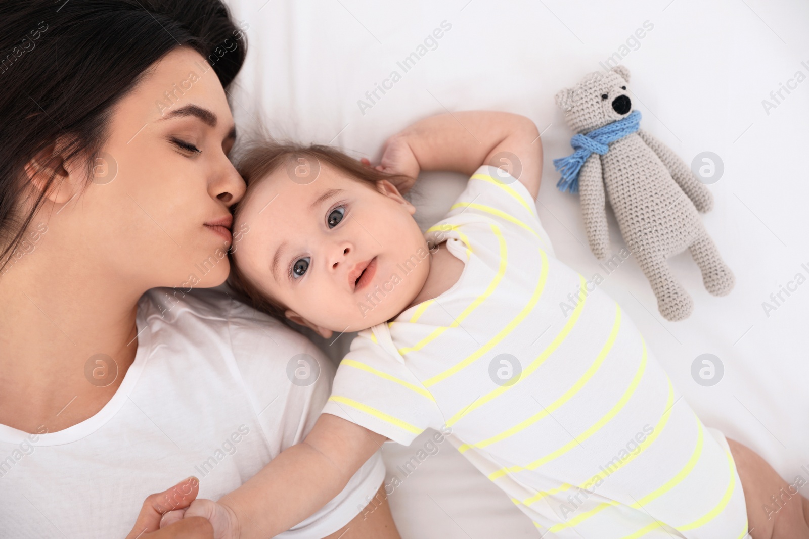 Photo of Portrait of mother with her cute baby lying on bed, top view