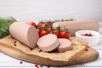 Delicious liver sausages and other products on white wooden table