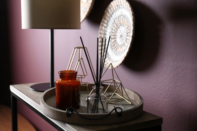 Wooden tray with decorations and lamp on table indoors