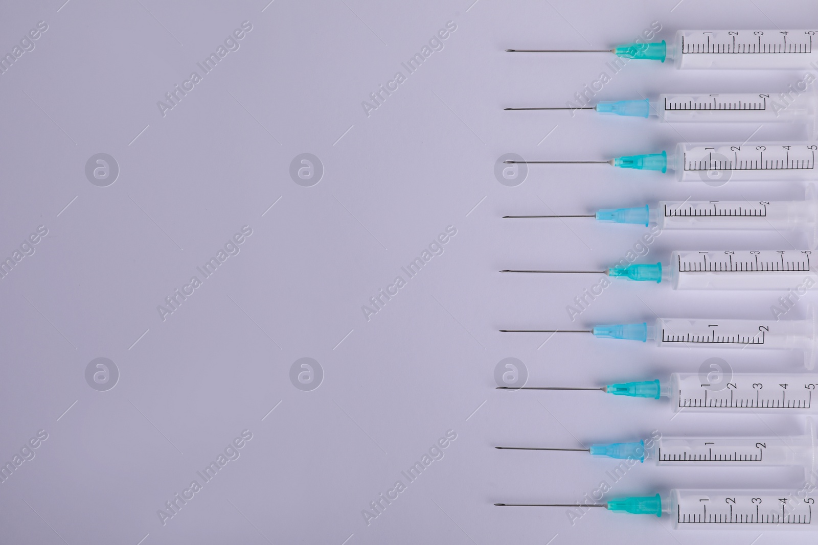 Photo of Disposable syringes with needles on white background, flat lay. Space for text