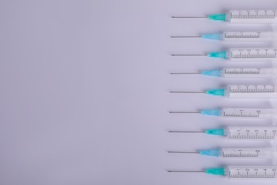 Photo of Disposable syringes with needles on white background, flat lay. Space for text