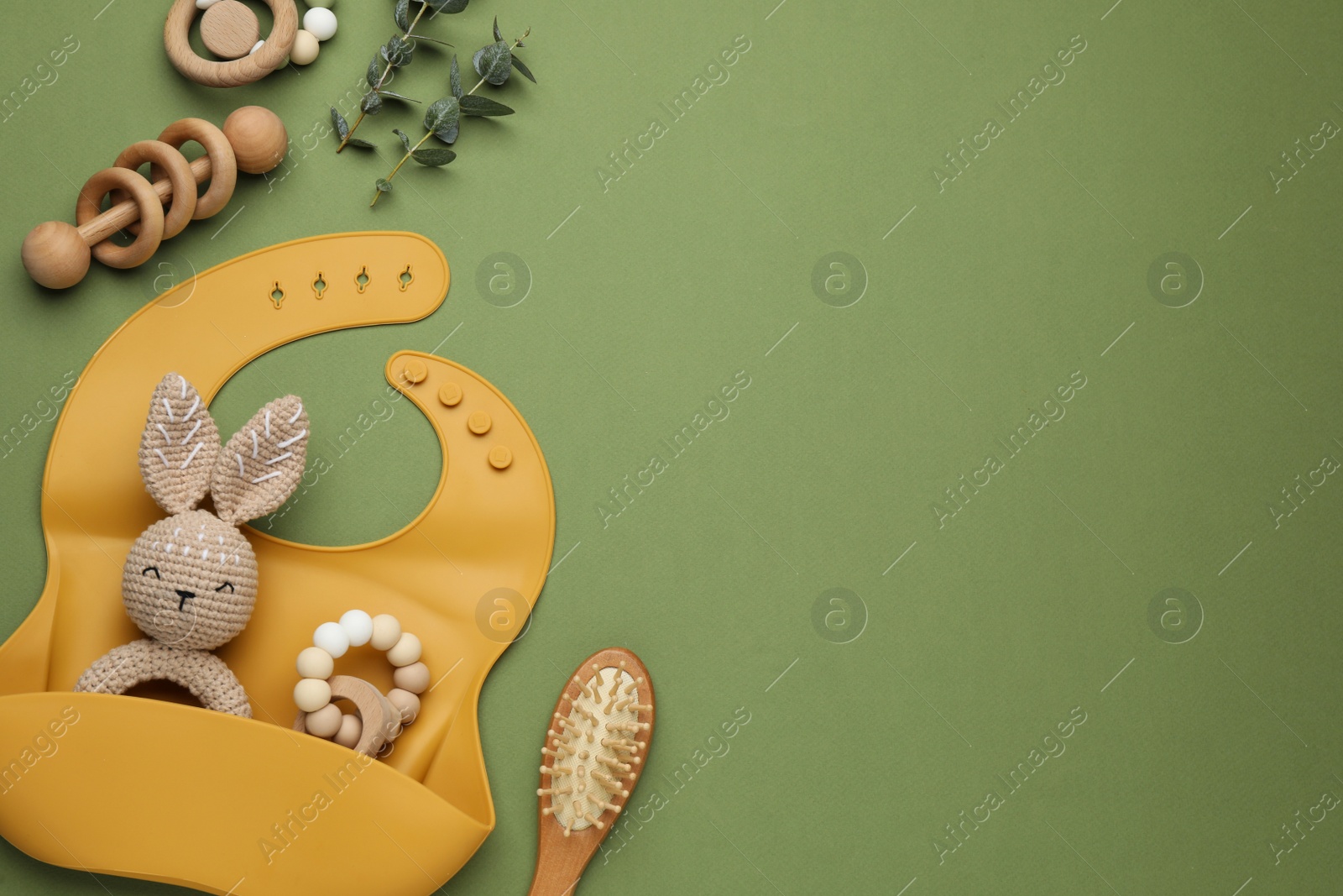 Photo of Flat lay composition with baby accessories and bib on green background, space for text